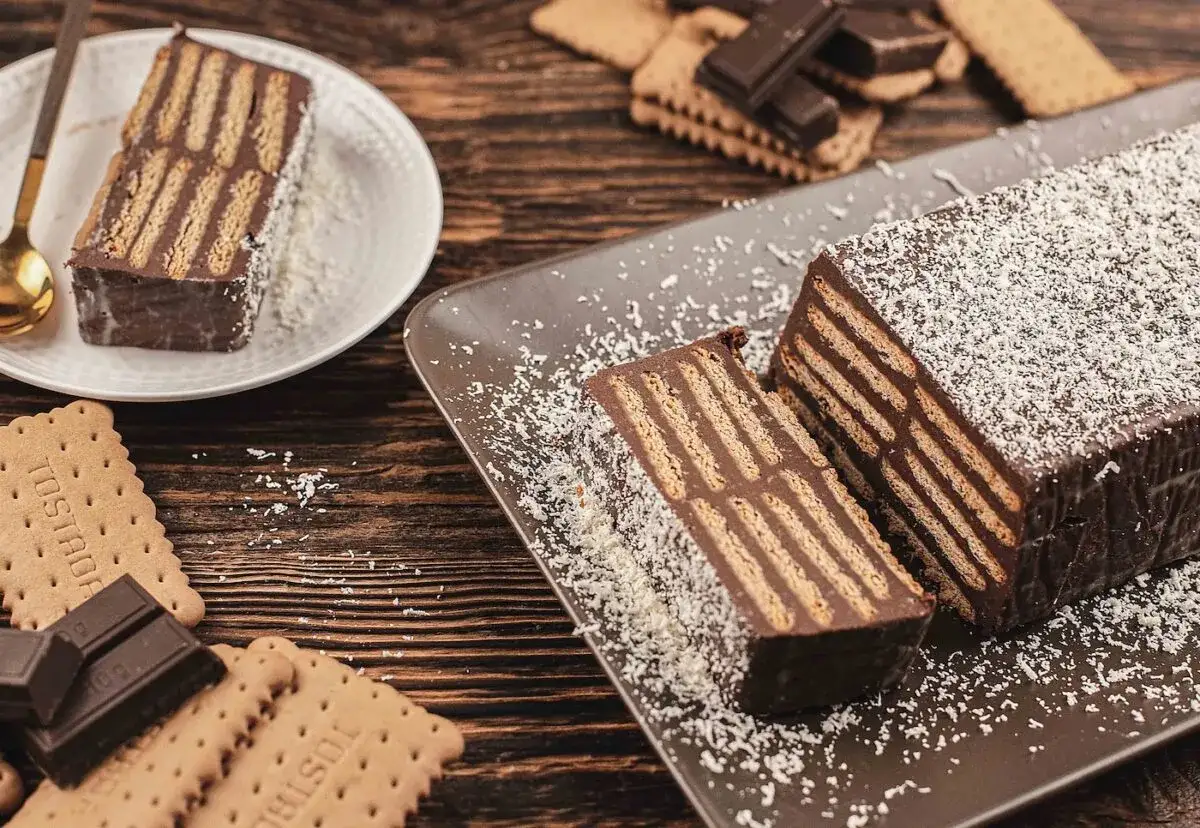 Tarta de chocolate y galletas, un postre casero con capas de galleta y chocolate, espolvoreada con coco rallado.