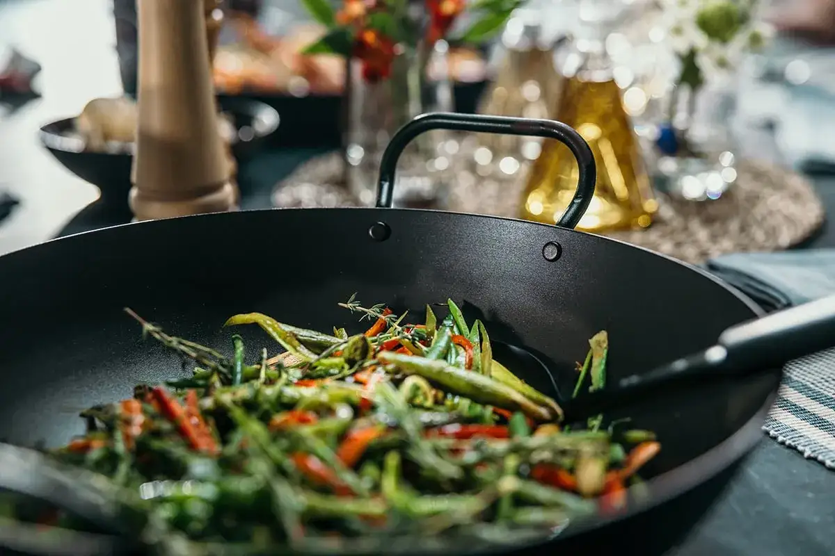 Un delicioso salteado de verduras reci&eacute;n hecho en un wok, con pimientos rojos y verdes, jud&iacute;as y hierbas arom&aacute;ticas.