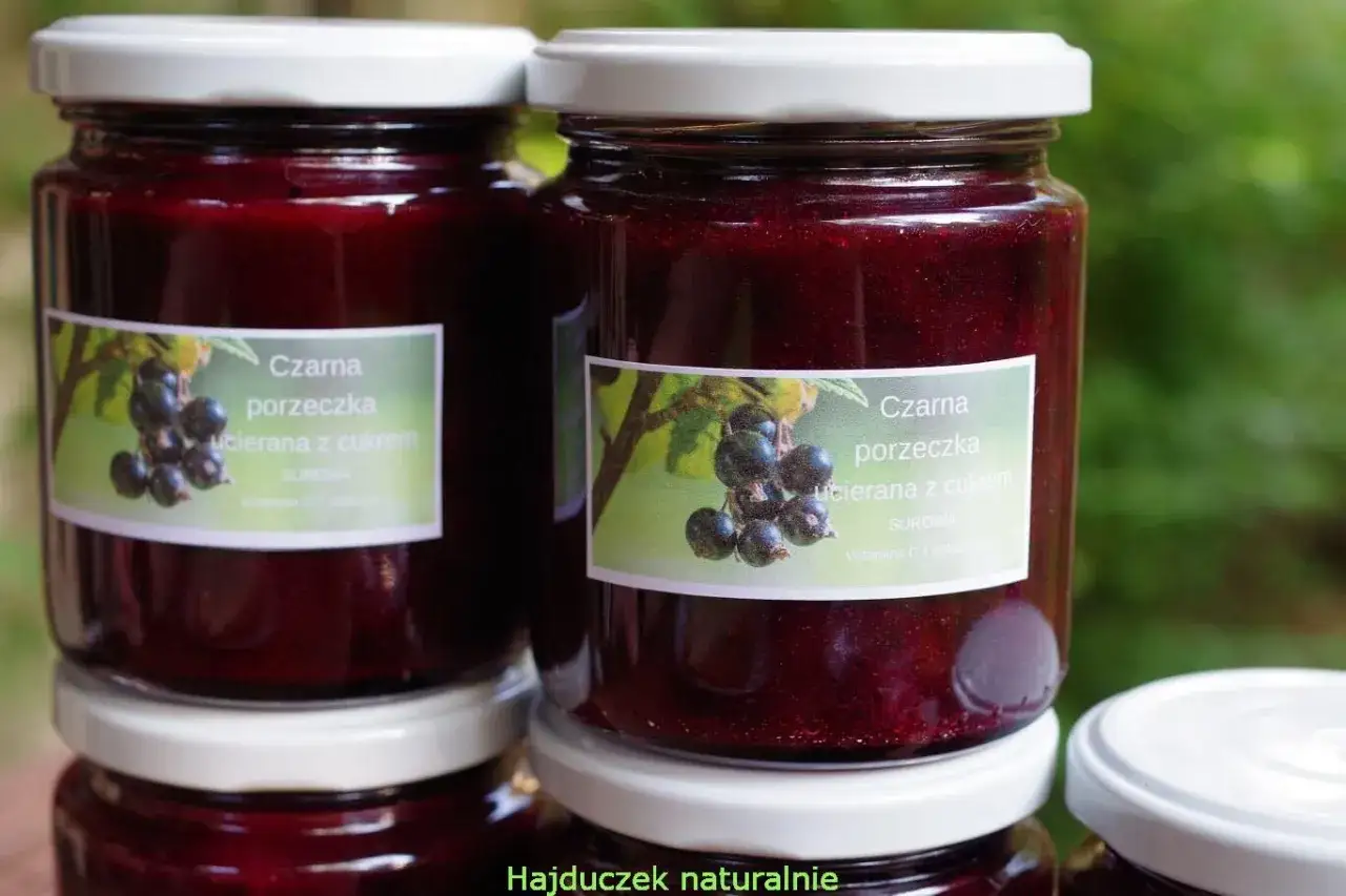 Słoiki z przetartą czarną porzeczką z cukrem. Naturalny smak lata zamknięty w słoiku.