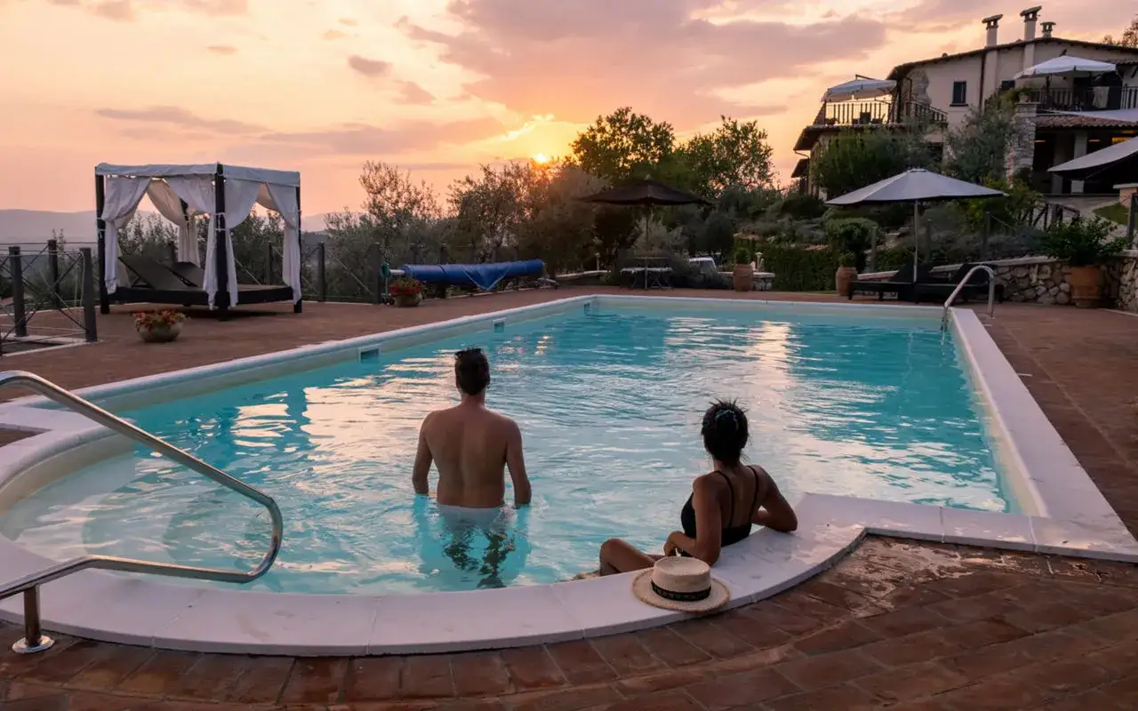 Coppia si gode un tramonto in piscina, un momento perfetto per le vacanze in fattoria.