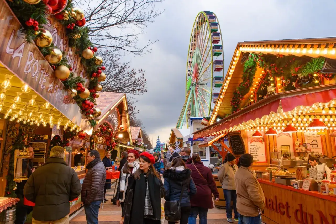 Ambiance féerique d'un marché de Noël en Île-de-France, avec ses chalets illuminés, sa grande roue et ses visiteurs joyeux.