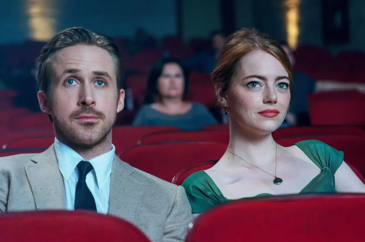 Ryan Gosling i Emma Stone, czyli la la land obsada, siedzą w kinie, patrząc w górę.