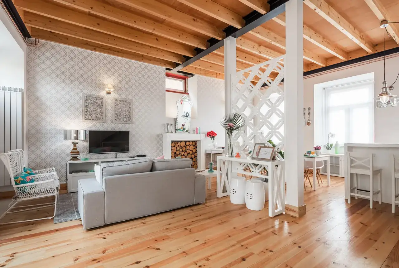 Offene Raumgestaltung mit stilvoller Trennung von Wohnzimmer und Esszimmer. Holzbalkendecke, Kamin und moderne Möbel.