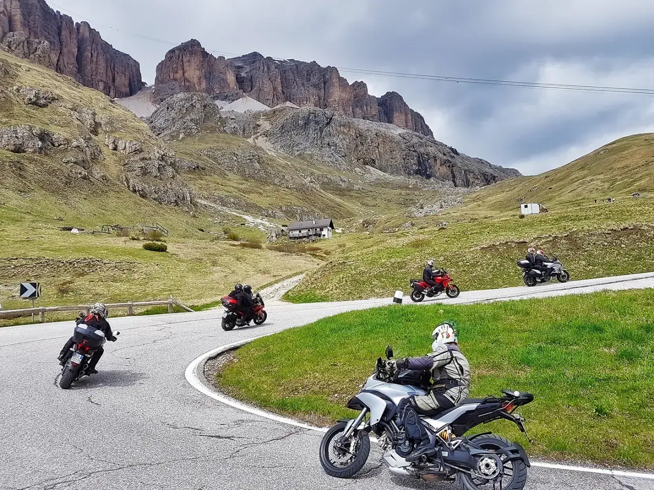 Motociclisti affrontano i passi del Trentino, tra montagne imponenti e curve panoramiche.