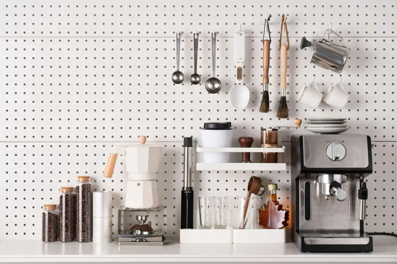 Kaffeemaschine, Moka-Kanne, Gl&auml;ser und Kaffeebohnen in Gl&auml;sern &ndash; alles ordentlich an der Wand befestigt, um **Stauraum schaffen** zu k&ouml;nnen.