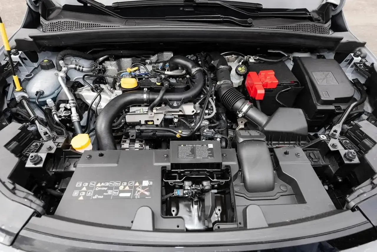 Vue du compartiment moteur d'une voiture, montrant le moteur TCE 90, réputé pour sa fiabilité.