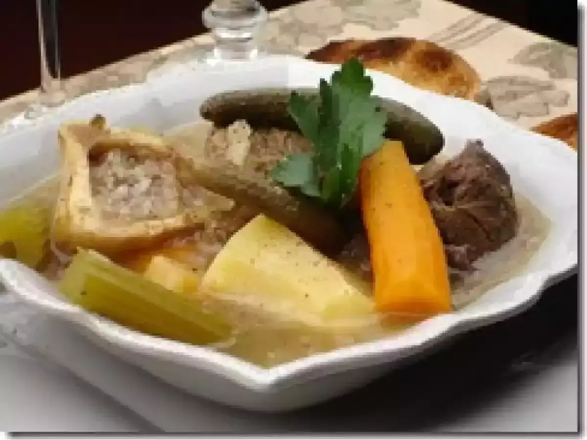 Un réconfortant pot-au-feu avec os à moelle, carottes, pommes de terre, céleri et cornichons, garni de persil frais.