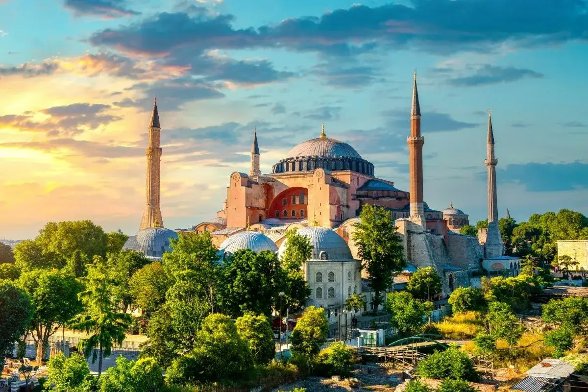 Majestatyczna Hagia Sophia w Stambule, otoczona zielenią, w blasku zachodzącego słońca. Czy to Stambuł, czy Istambuł, piękno pozostaje niezmienne.