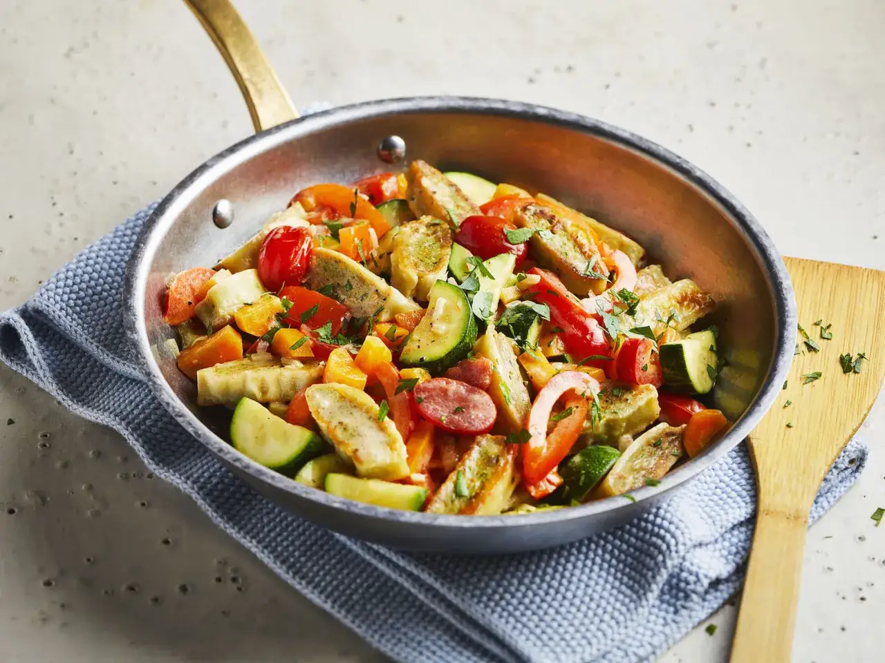 Bunte Maultaschen-Pfanne mit Gemüse wie Zucchini, Paprika und Tomaten, garniert mit Petersilie. Ein köstliches Gericht, das Lust auf mehr macht.