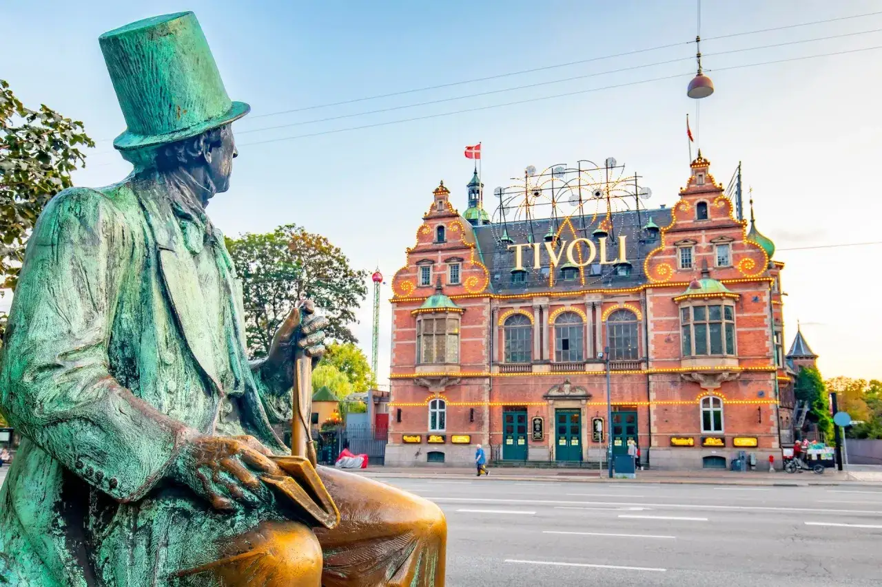 Statue blickt auf das beleuchtete Tivoli in Kopenhagen. Ein Muss, wenn man wissen will, was man in Kopenhagen gesehen haben muss!