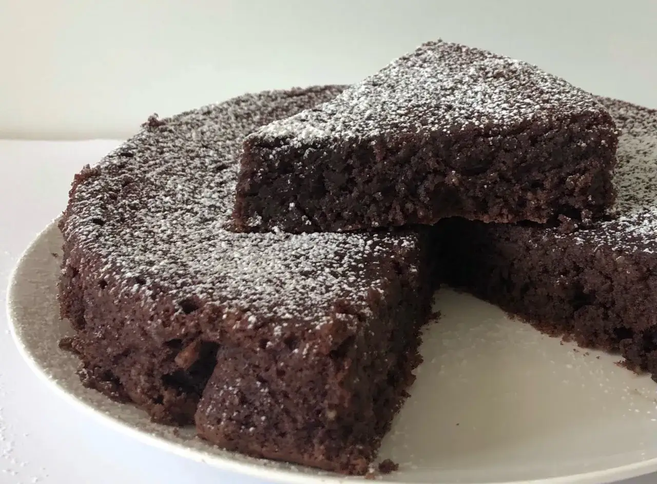 Torta Caprese, ricetta originale napoletana, soffice e golosa, cosparsa di zucchero a velo.