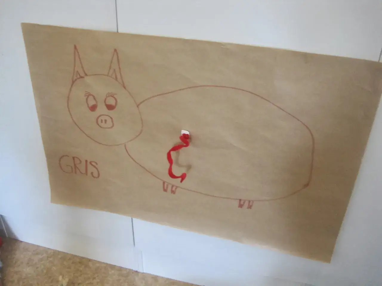En teckning av en gris p&aring; brunt papper, med ordet 