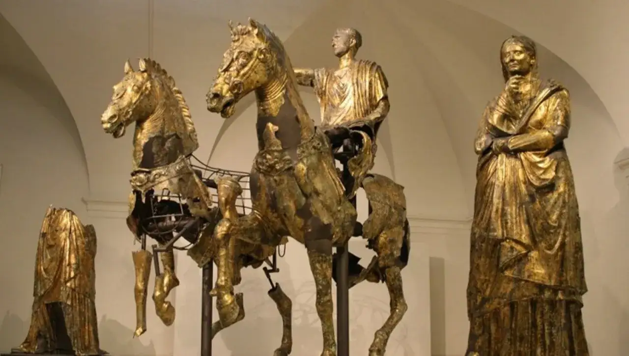 Statue equestre in bronzo dorato, forse un imperatore romano, con due cavalli e figure femminili. La **pergola pu** è un elemento architettonico che non appare in questa immagine.