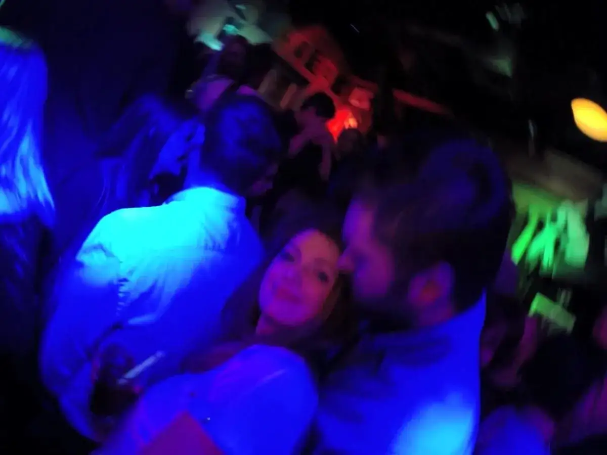 Impreza w **Sopot**! Ludzie tańczą w klubie, otoczeni niebieskim i zielonym światłem.