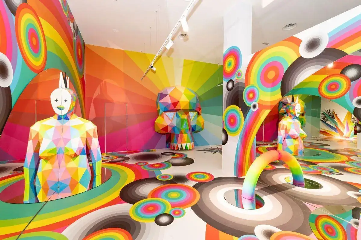 Un espacio vibrante que muestra esculturas geom&eacute;tricas y murales de arco&iacute;ris. Un cr&aacute;neo colorido y figuras humanas facetadas ejemplifican qu&eacute; es el arte contempor&aacute;neo.