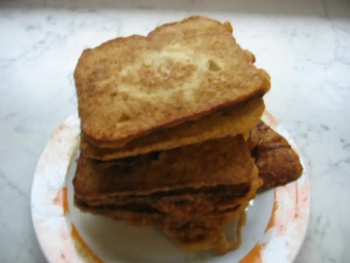 Ein Stapel goldbraunes Brot mit Ei, perfekt für ein herzhaftes Frühstück.