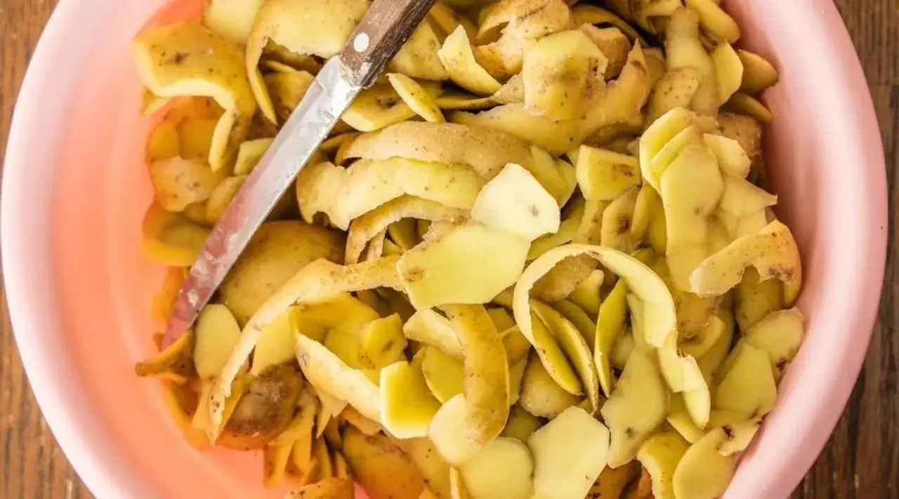 Obierki z ziemniaków inaczej, w różowych misce, z widocznym nożem. Gotowe do dalszego wykorzystania.