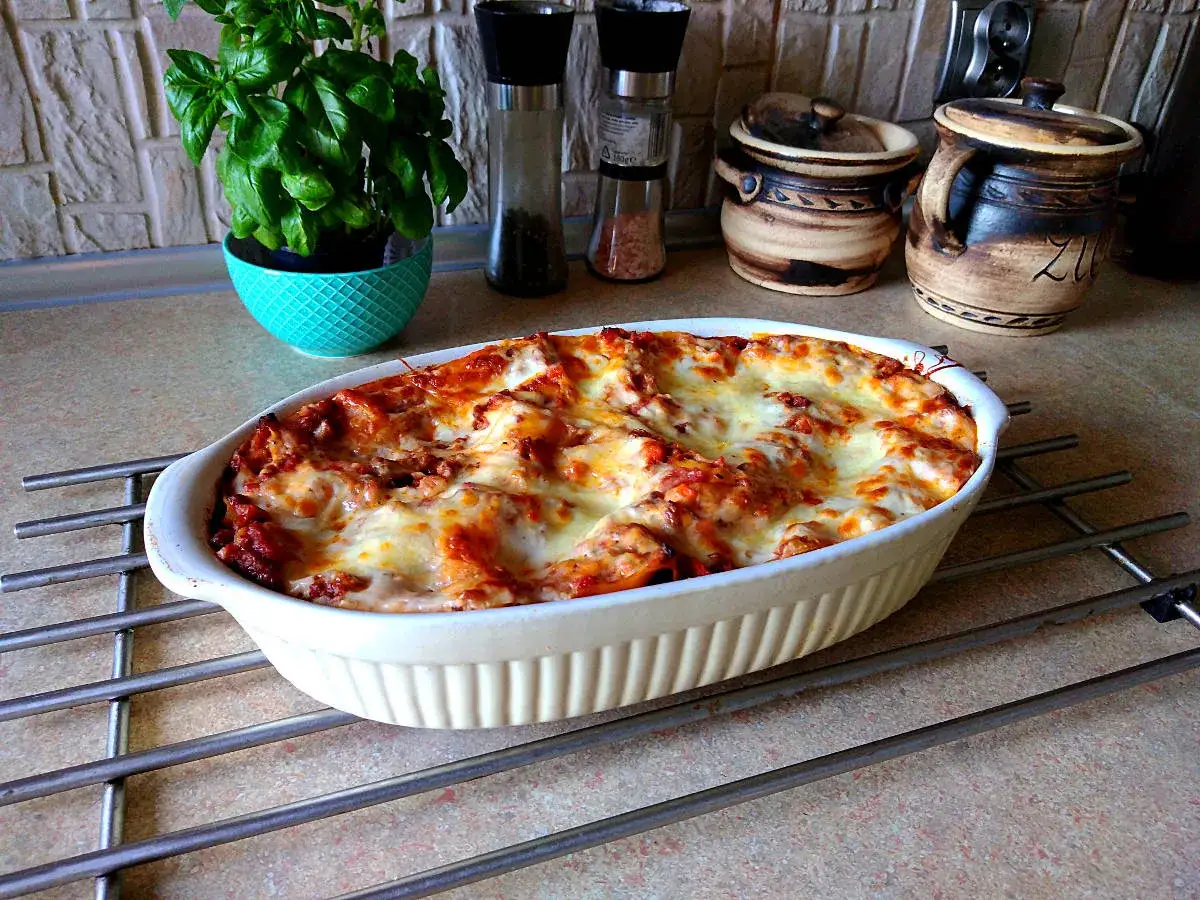 Pyszna, gorąca lasagne w białym naczyniu, gotowa do podania. Idealna na rodzinny obiad.