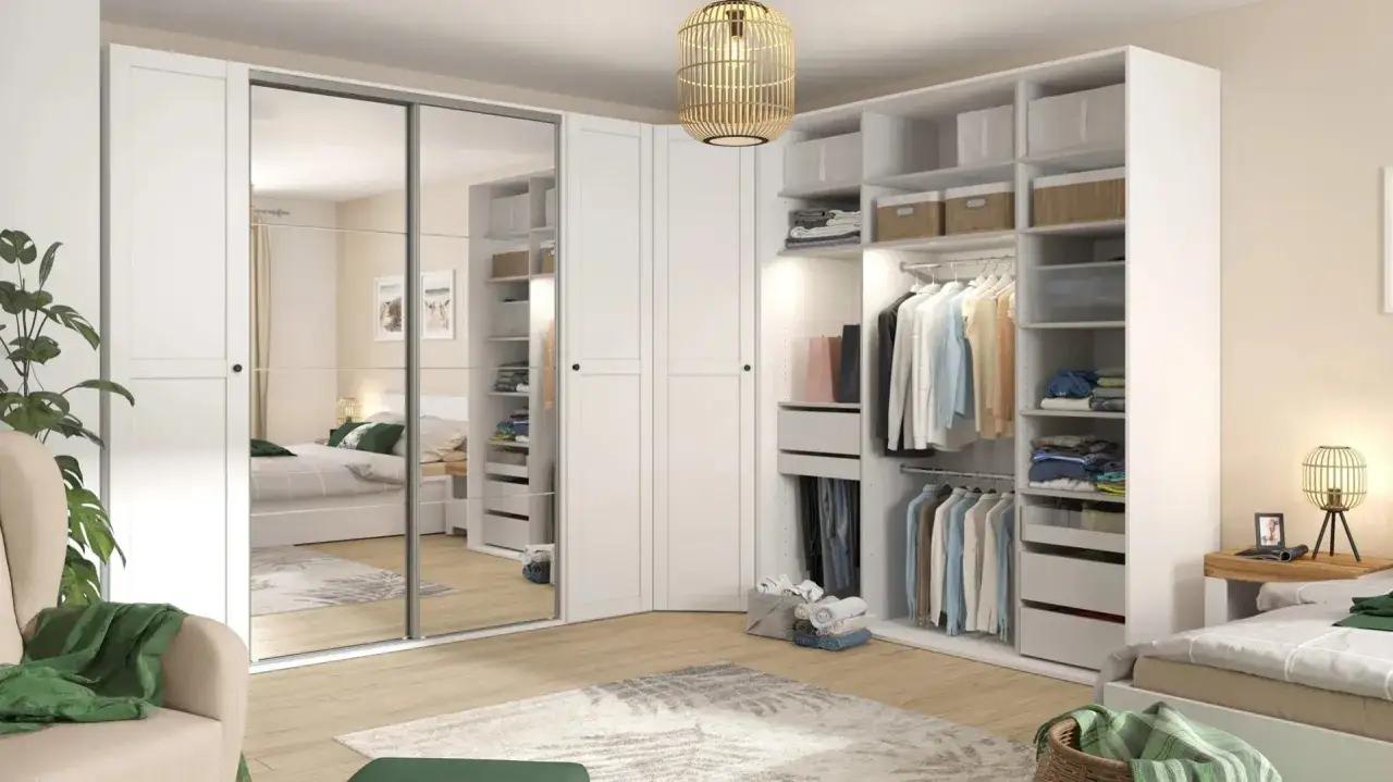 Zorganizowana garderoba w stylu konmari: wieszaki z ubraniami, półki z pudełkami i złożonymi rzeczami, lustrzane drzwi szafy.