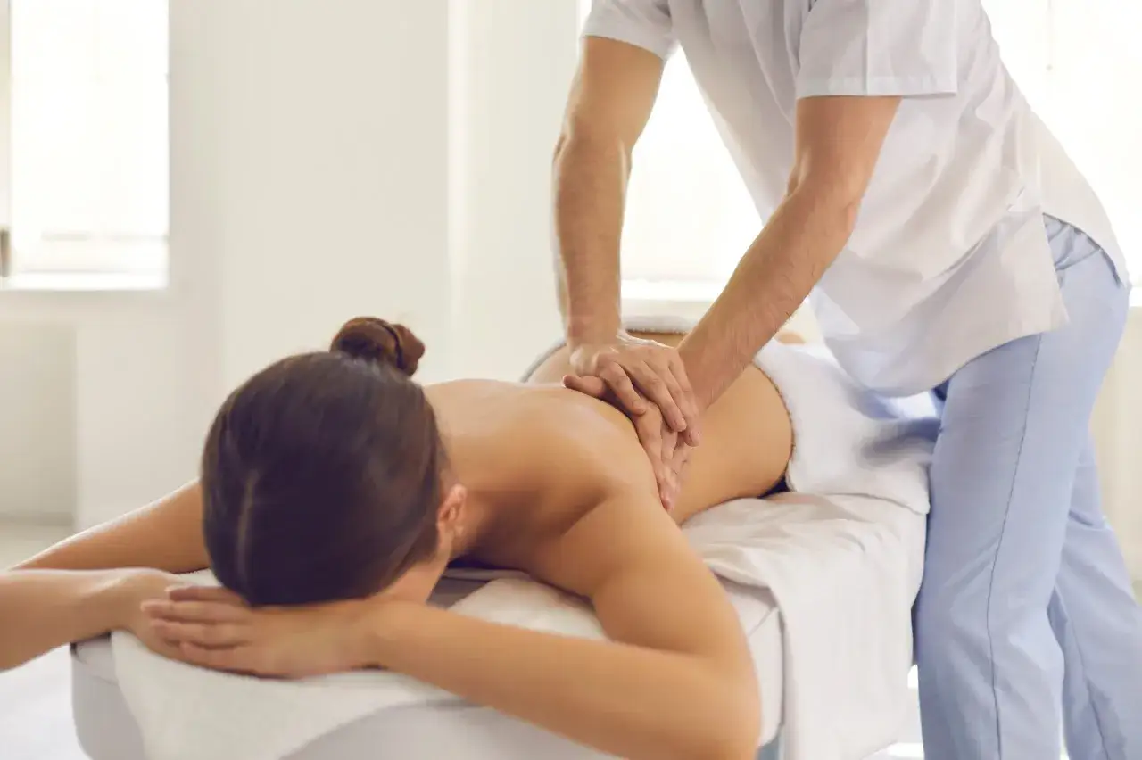 Relaksacyjny masaż plec&oacute;w. Terapeuta wykonuje głęboki masaż, kt&oacute;ry może być jednym z wielu rodzaj&oacute;w masażu relaksacyjnego.
