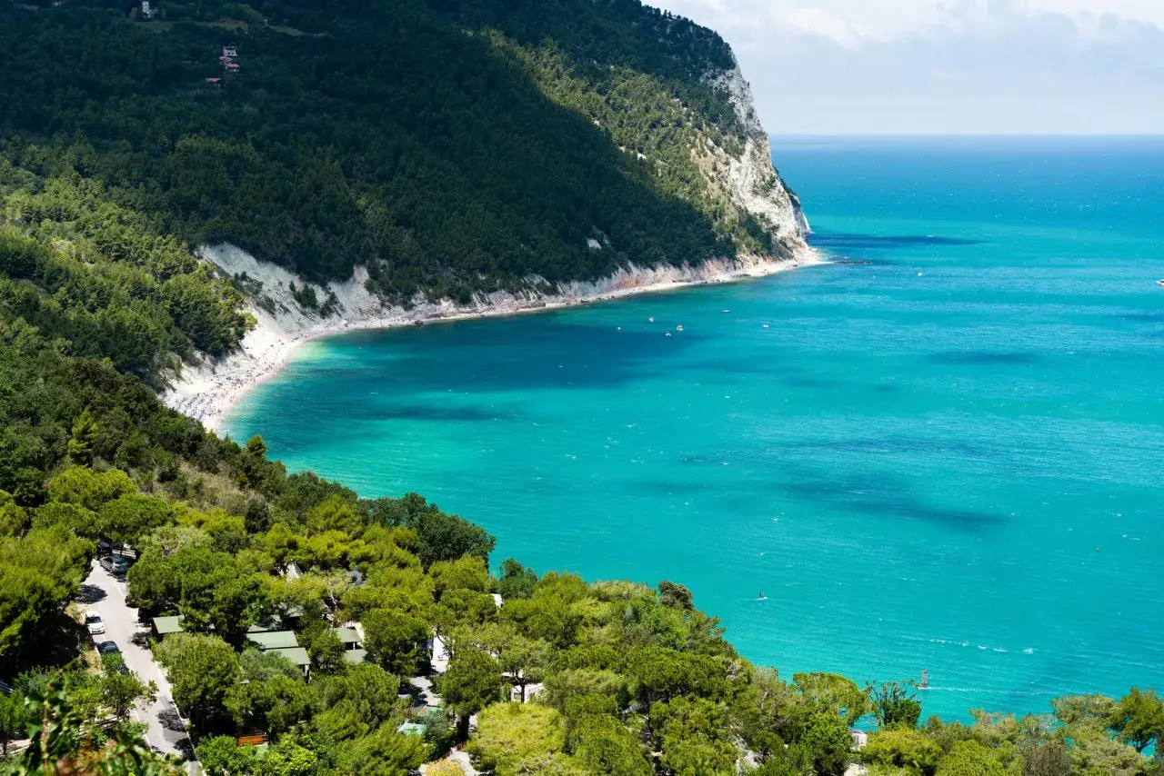 Spiaggia affollata e mare turchese, un campeggio immerso nel verde. Perfetto per scoprire le localit&agrave; balneari Marche economiche.