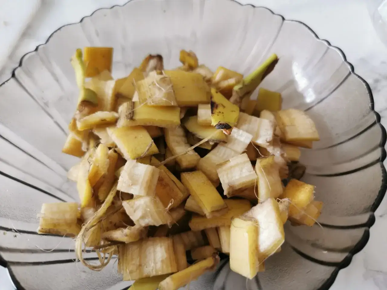 Pokrojone skórki bananów w misce, gotowe do stworzenia naturalnego nawozu z banana dla roślin.