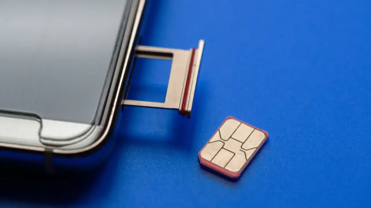 Un smartphone avec son tiroir carte SIM ouvert et une carte SIM &agrave; c&ocirc;t&eacute;. Astuce pour comment ouvrir le tiroir carte SIM sans outil.
