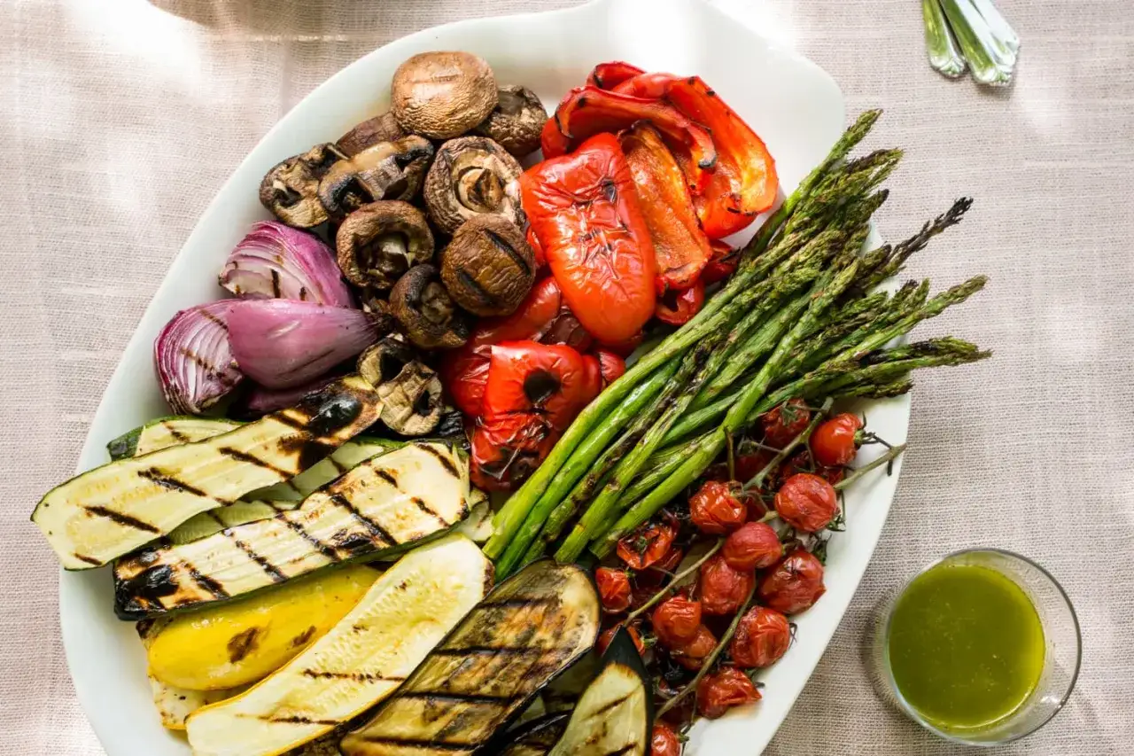 Pyszne warzywa na grilla: grillowana cukinia, bakłażan, papryka, cebula, pieczarki, szparagi i pomidorki koktajlowe.