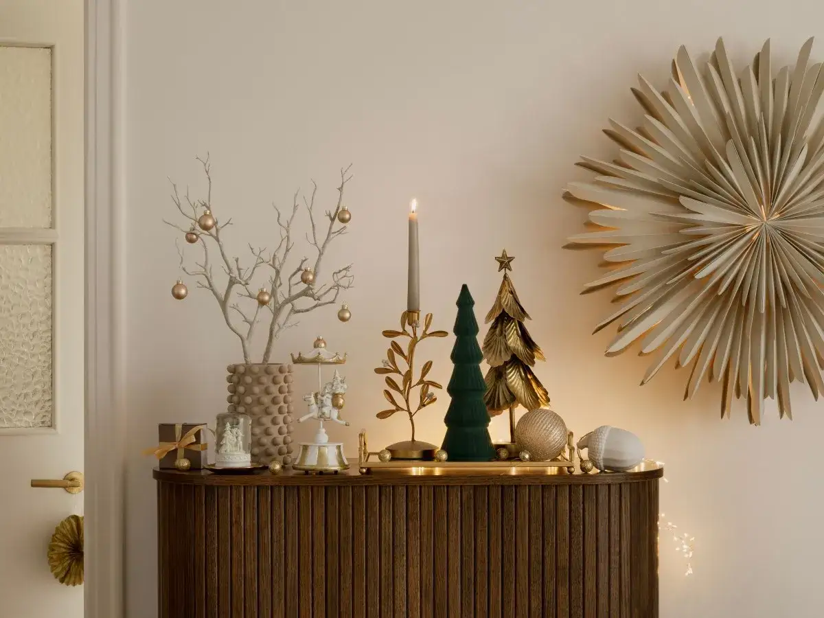 Decorar recibidor navidad con &aacute;rbol seco adornado, cascanueces, mini &aacute;rboles y estrella dorada.