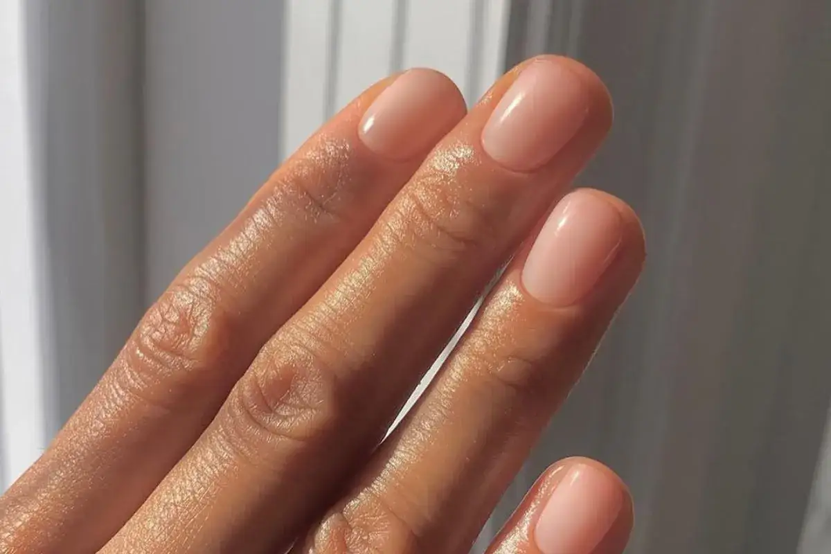 Dłonie z delikatnym, różowym połyskiem na paznokciach. Choć manicure japoński wady ma niewielkie, warto o nich pamiętać.