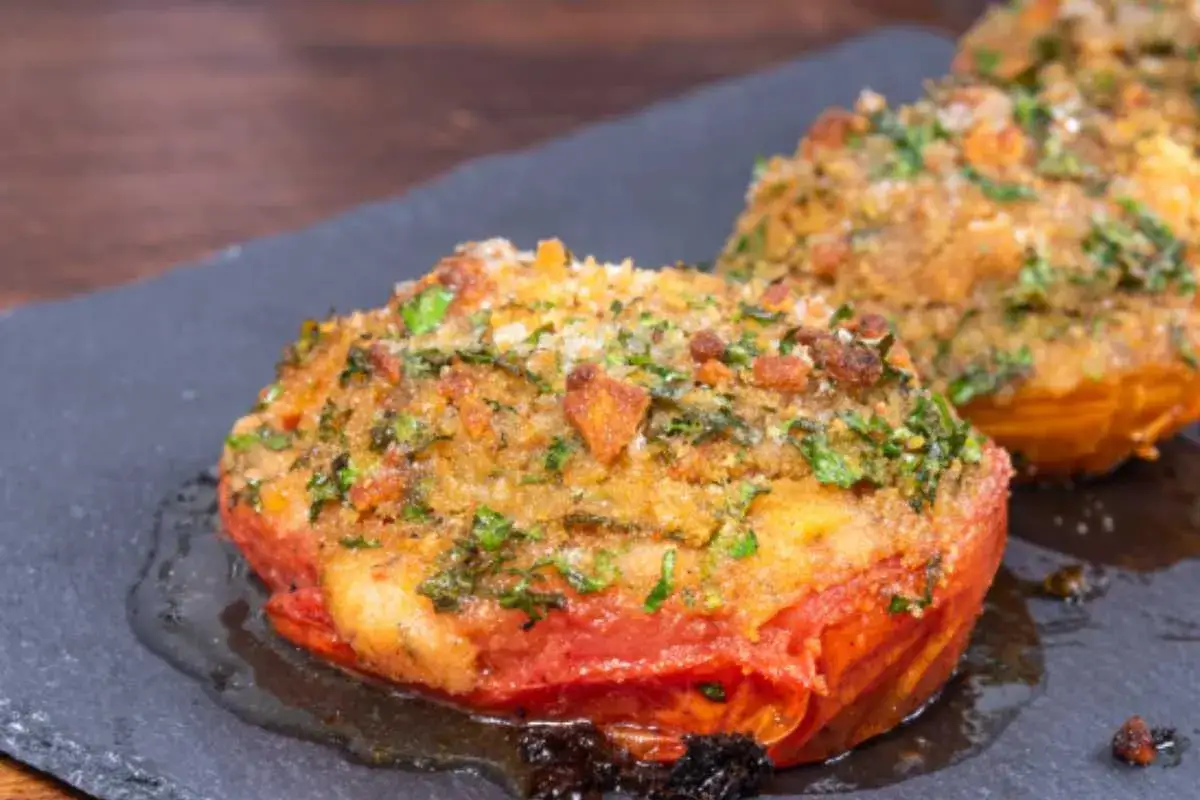 Pomodori gratinati in padella, dorati e croccanti, con erbe aromatiche e pangrattato. Un contorno saporito e invitante.