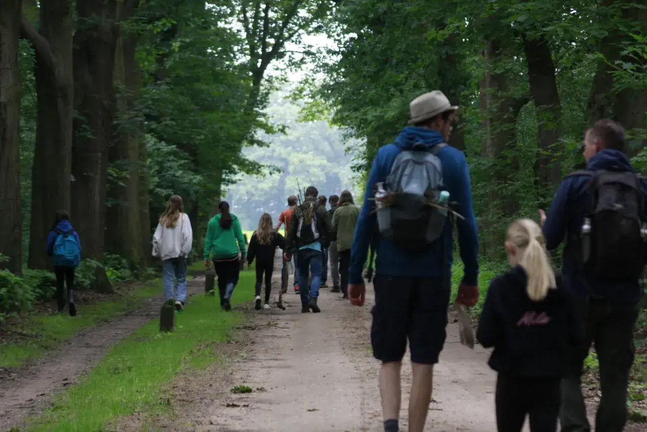 Een vader en dochter lopen hand in hand over een bospad, een beeld van pure liefde tussen vader en dochter.