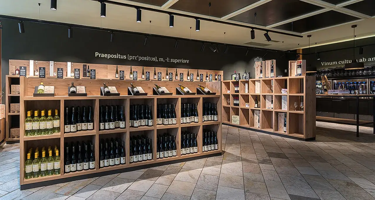 Weinverkauf im Kloster Neustift: Regale voller Flaschen, von Weißwein bis Rotwein, laden zum Probieren ein.