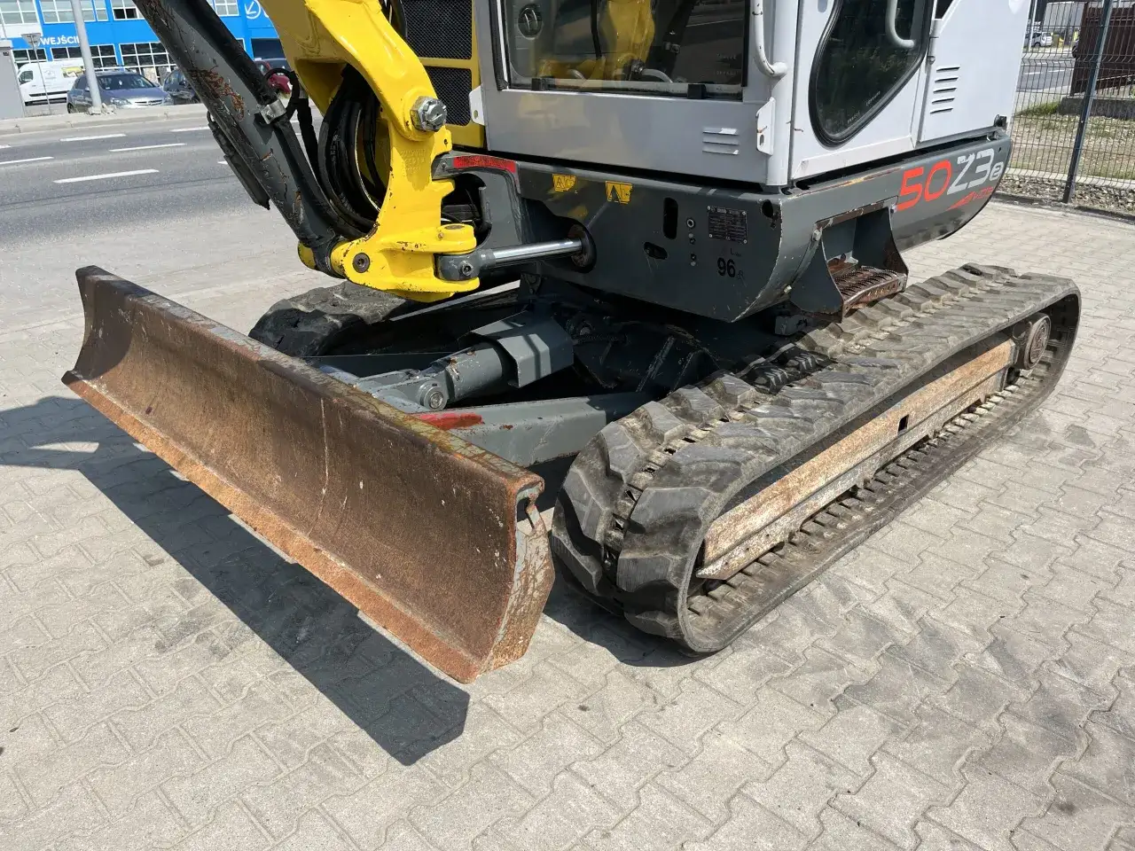 Głęboki cień rzuca minikoparka Wacker Neuson 50Z3, gotowa do pracy na placu budowy.
