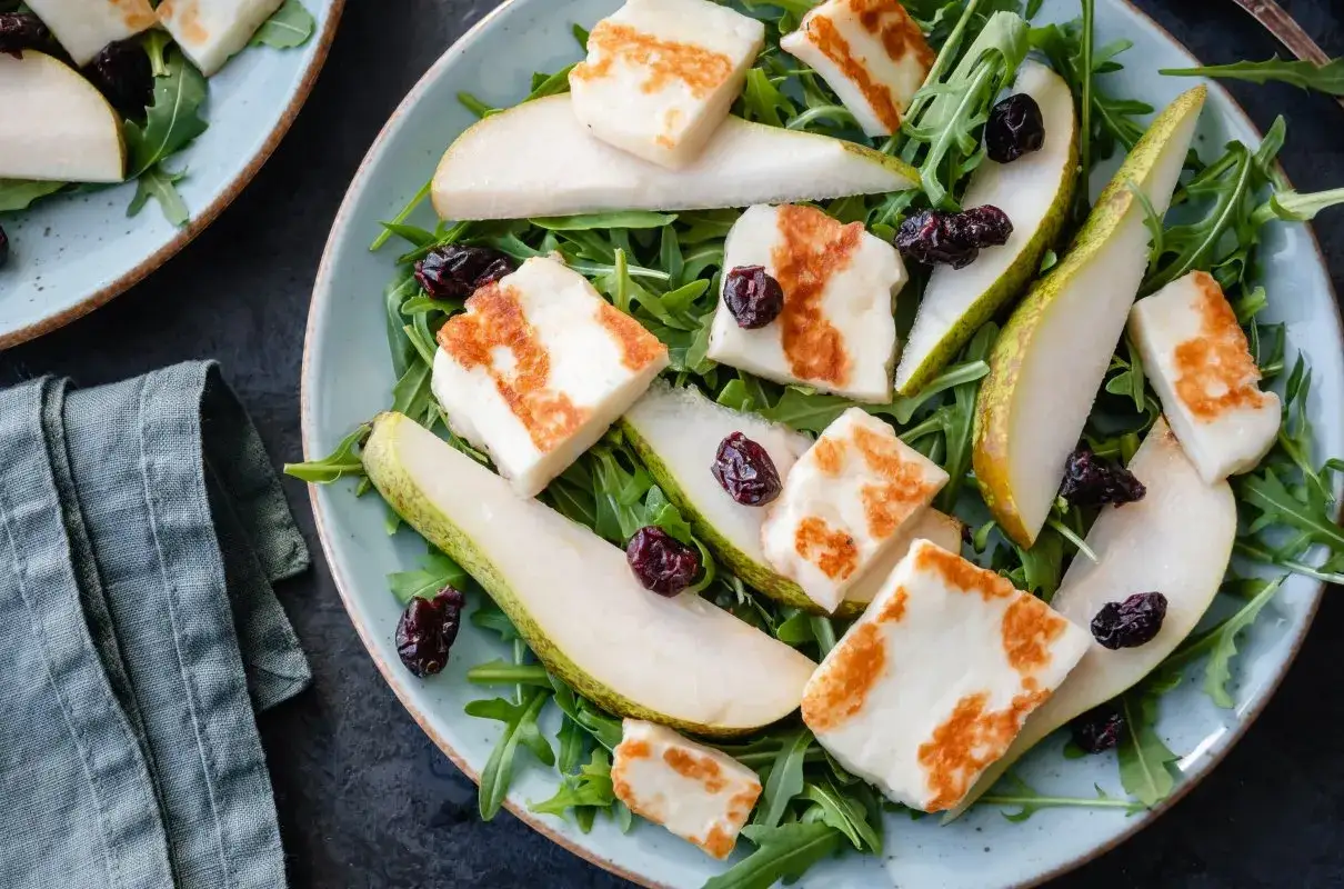 Pyszna sałatka z halloumi i rukolą, z dodatkiem soczystej gruszki i suszonej żurawiny.