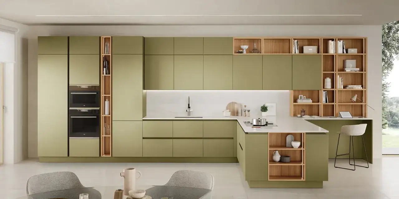Cucina verde e legno con mobili moderni, elettrodomestici integrati, piano di lavoro in quarzo e scaffalature a vista.
