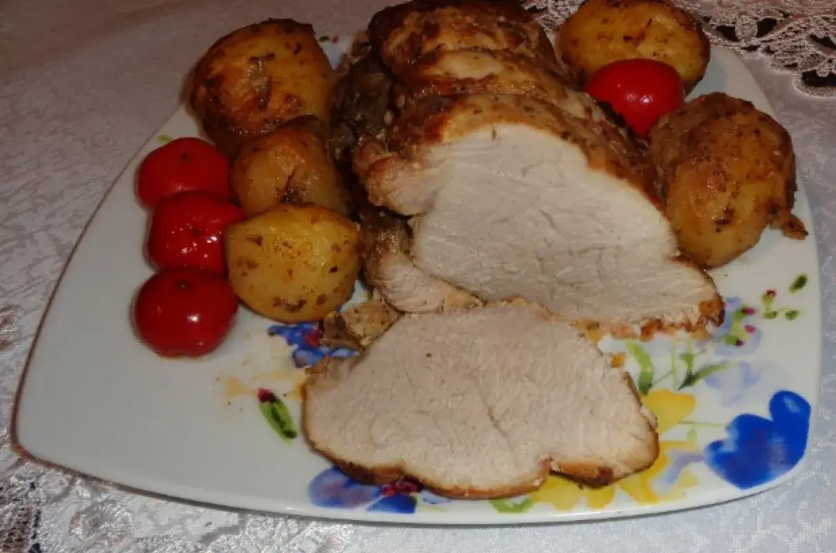 Pyszna szynka na obiad z pieczonymi ziemniaczkami i pomidorkami.