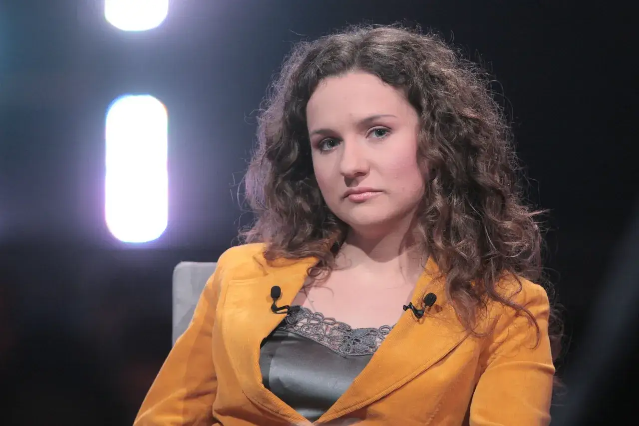 Kobieta z kręconymi włosami w musztardowej marynarce, być może kim jest żona Cejrowskiego.