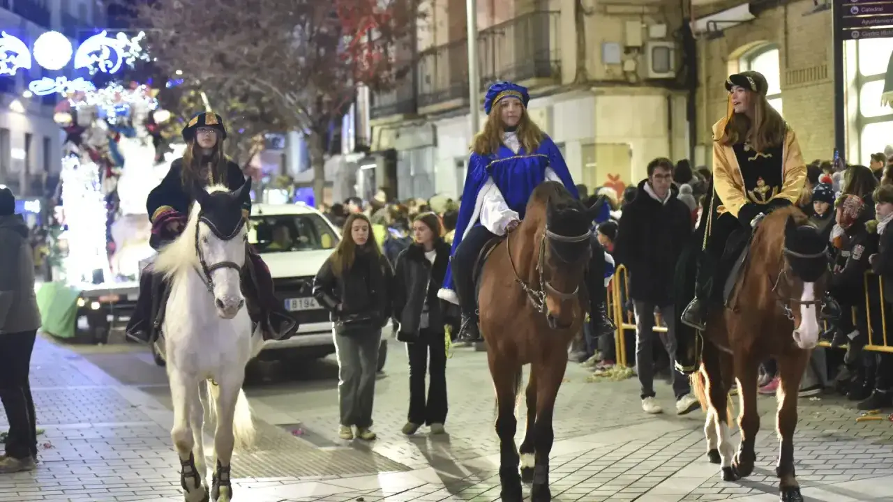 Tres jóvenes a caballo, ataviadas como reyes magos, participan en la cabalgata de Reyes en Huesca.