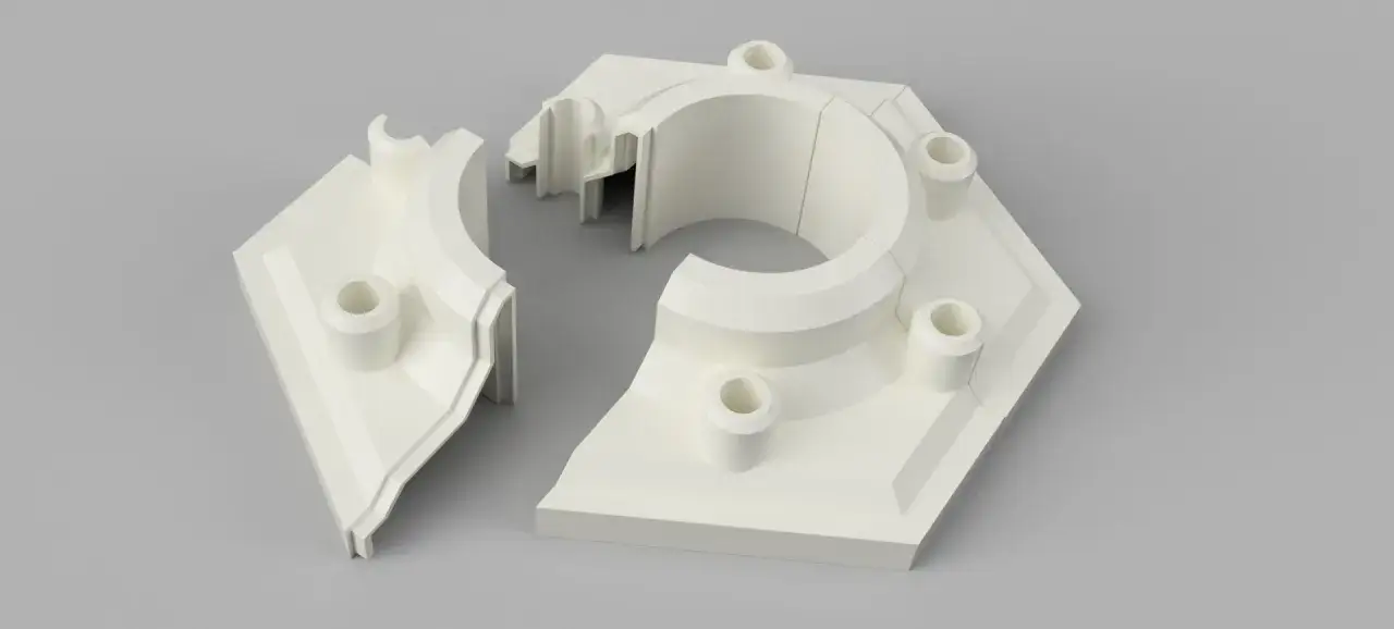 Two white 3D printed large objects, resembling parts of a hexagonal structure with cylindrical protrusions, are shown on a gray background.