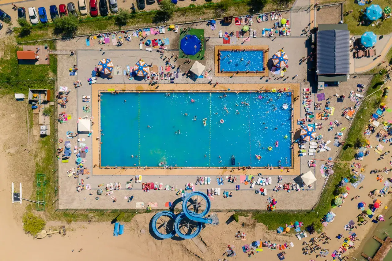 Letnie popołudnie na kąpielisku Mała Chorwacja. Ludzie odpoczywają na plaży i kąpią się w basenie.