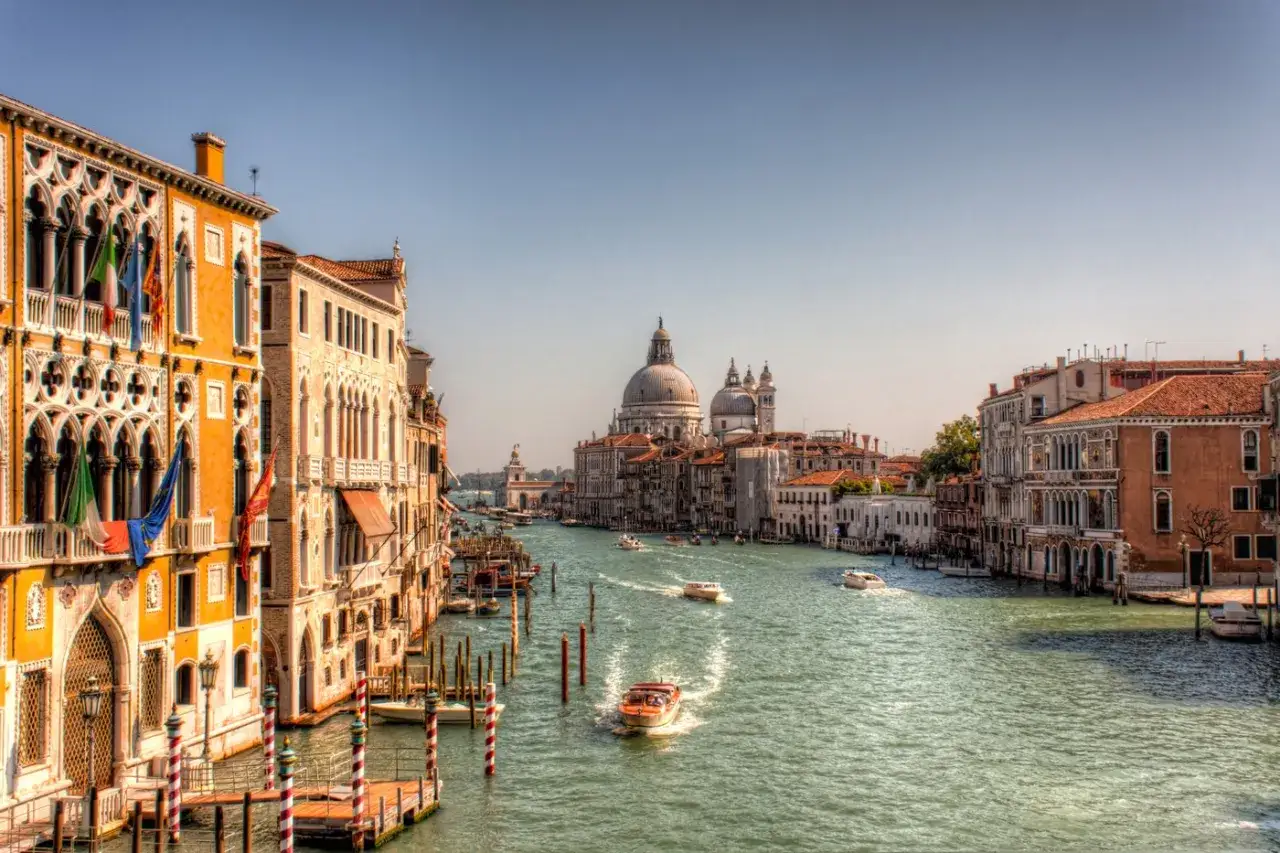 Un canal &agrave; Venise, avec des bateaux naviguant entre les palais color&eacute;s. L'envie d'aller &agrave; Venise est forte en voyant ce paysage.