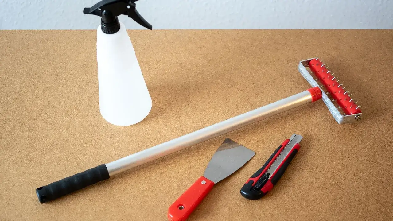 Werkzeuge f&uuml;r die mietwohnung tapete entfernen: Spr&uuml;hflasche, Spachtel, Cuttermesser und eine Stachelwalze.