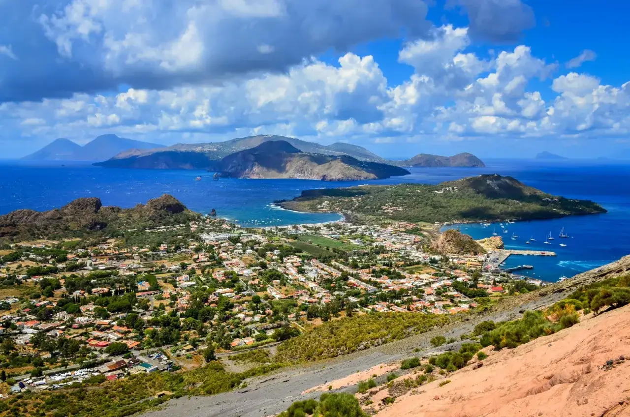 Panoramica mozzafiato delle isole siciliane pi&ugrave; belle, con case bianche, mare blu intenso e montagne verdi.