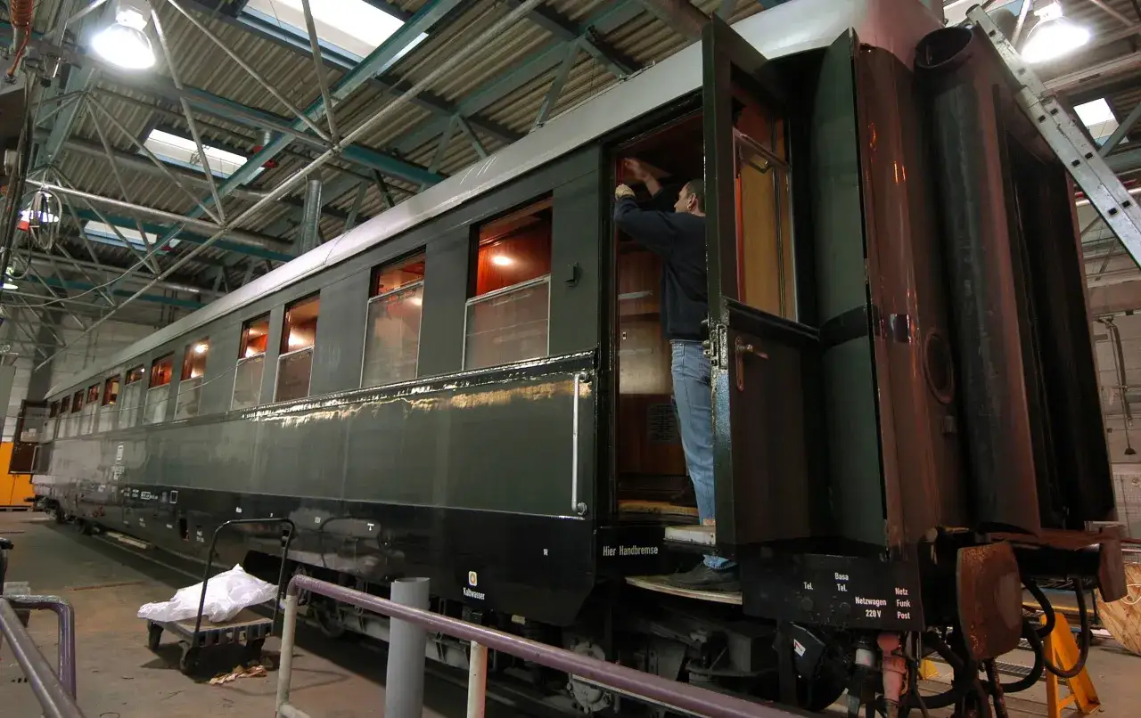 Ein Mann repariert einen historischen Waggon, der Teil von Hitlers Panzerzug war.
