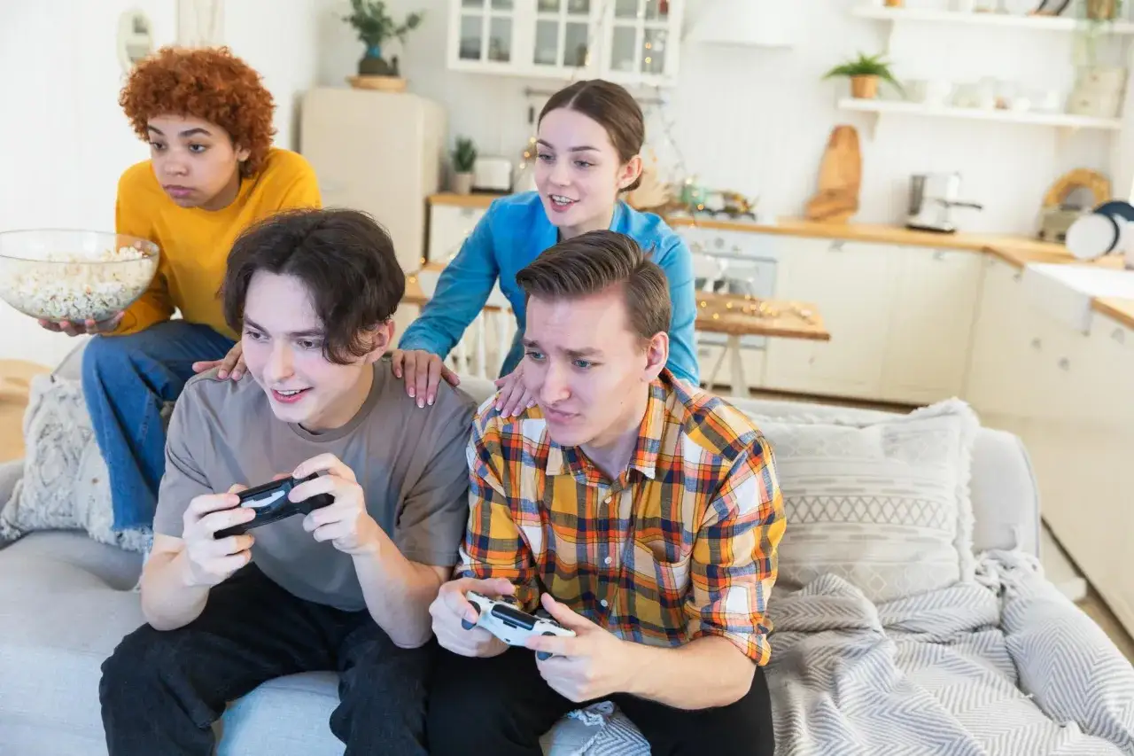 Czterech przyjaciół gra w gry na Steam, jeden z nich trzyma miskę popcornu.