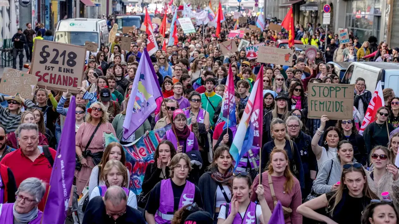 Menschen demonstrieren f&uuml;r Frauenrechte. Ein Schild fordert 