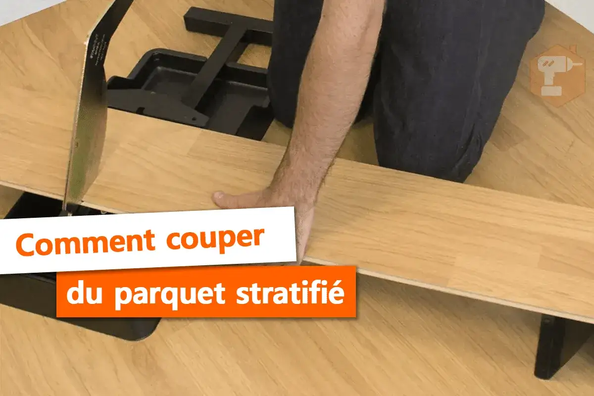 Main tenant une lame pour la coupe parquet flottant, une personne prépare la pose.