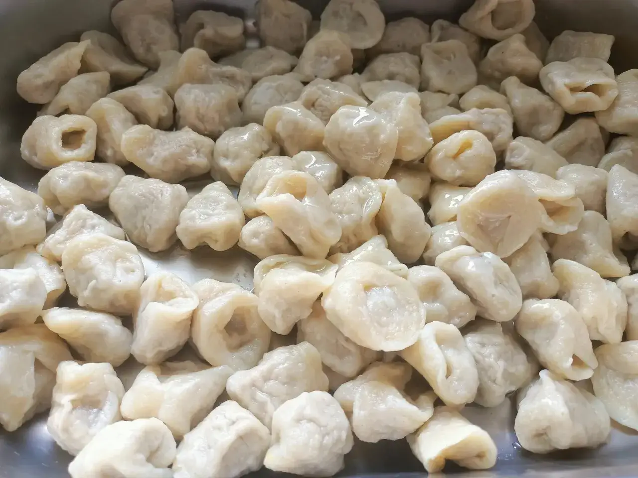 Pyszne, domowe pierogi w metalowej misce. Idealne na rodzinny obiad w jednej z **ciekawych restauracji w okolicach Krakowa**.
