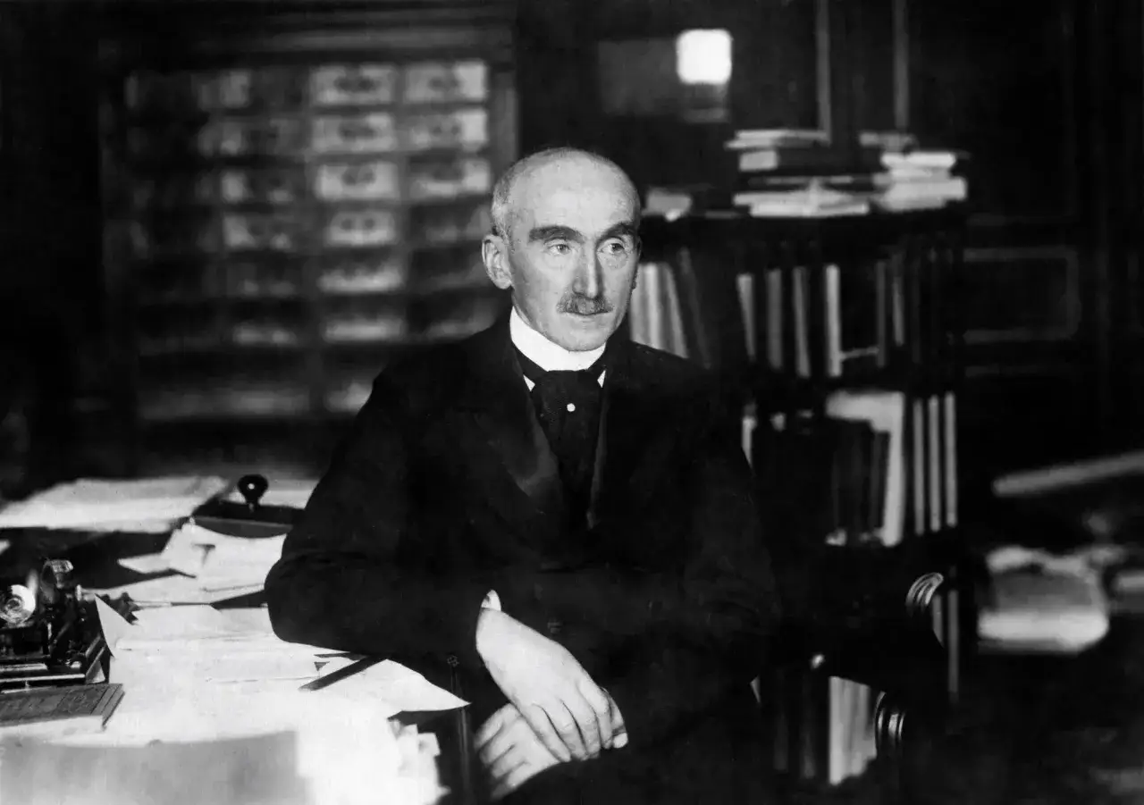 Henri Bergson, pensif, r&eacute;fl&eacute;chit au temps dans son bureau, entour&eacute; de livres.